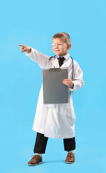 Cute Little Doctor Clipboard Pointing Something Blue Background — Stock Photo, Image