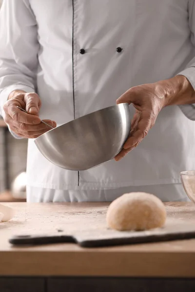 stock image Male chef making dough for pasta at table in kitchen, closeup