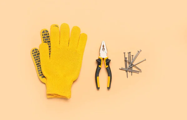 Gloves Pliers Nails Beige Background — Stock Photo, Image