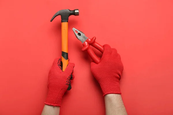 Male Hands Gloves Holding Pliers Hammer Red Background — Stock Photo, Image