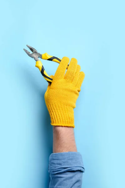 Mão Masculina Luvas Segurando Alicate Fundo Azul — Fotografia de Stock