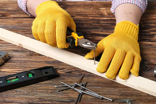 Man Pliers Pulling Out Nail Wooden Plank Table — Stock Photo, Image