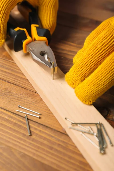 Man Pliers Pulling Nail Out Wooden Plank Table — Stock Photo, Image