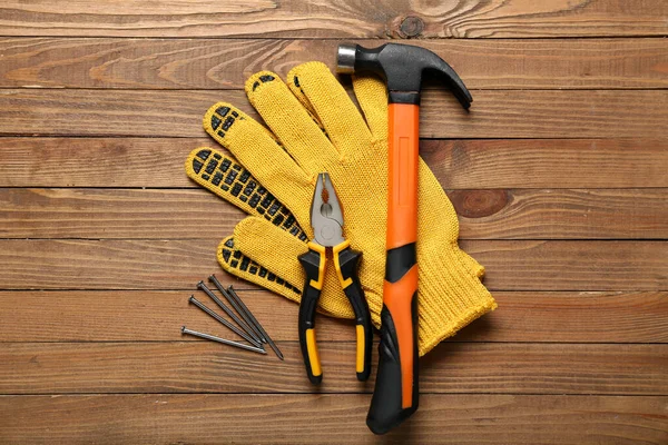 Zangen Handschuhe Und Nägel Auf Holzgrund — Stockfoto