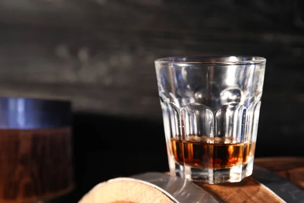 暗い木製の背景を背景に樽の上においしいウイスキーのガラス クローズアップ — ストック写真