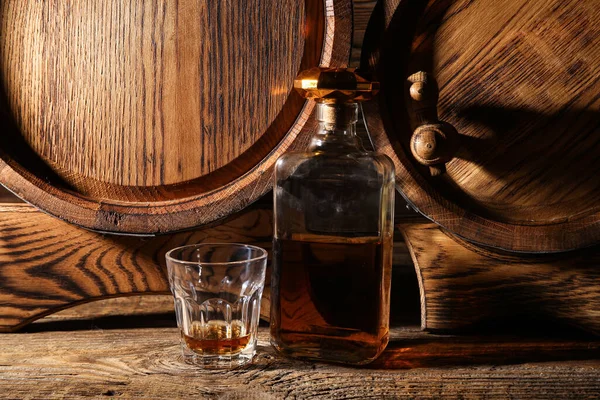木製の背景にオーク樽とおいしいウイスキーのボトルとガラス — ストック写真