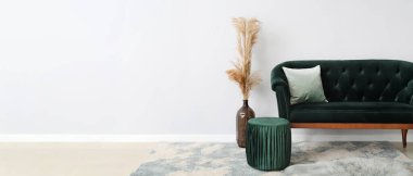 Yeni yeşil kanepe ve pouf, odanın ışık duvarının yanında. Tasarım için pankart