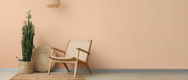 Bej duvarın yanında örülmüş puf ve koltuklu kaktüs. Tasarım için pankart