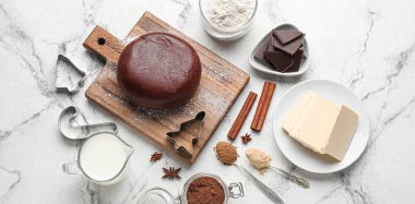 Beyaz mermer arka planda Noel kurabiyeleri hazırlamak için çikolata hamuru ve malzemeler