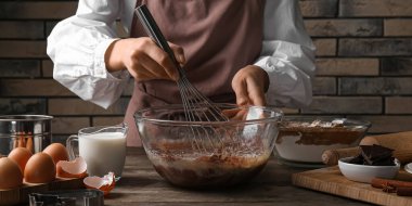 Mutfak masasında çikolata hamuru hazırlayan kadın, yakın plan.