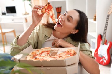 Evde bir kutu lezzetli pizzası olan güzel bir kadın, yakın plan.