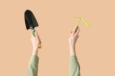 Bej arka planda araçları olan kadın bahçıvan