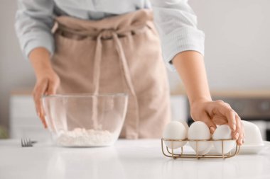 Mutfaktaki masada makarna için hamur yapan kadın, yakın plan.