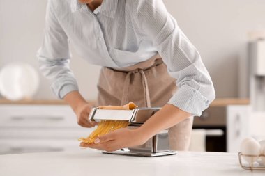 Mutfakta makineyle makarna yapan kadın, yakın plan.