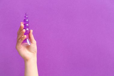 Mor arka planda anal tıpası olan kadın