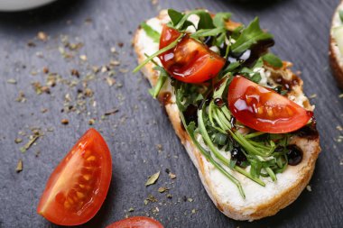 Krem peynirli lezzetli sandviç, roka ve domatesler tahtada, yakın plan.