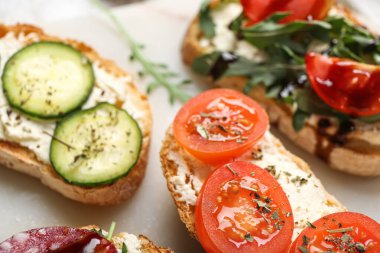 İçinde krem peynirli, domatesli ve salatalıklı lezzetli sandviçler var.