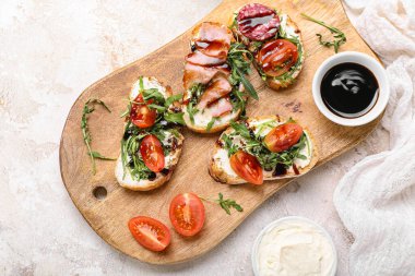 Nefis sandviçleri ve sosu olan ahşap bir tahta tabela.