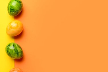 Sarı ve turuncu arka planda Paskalya yumurtaları