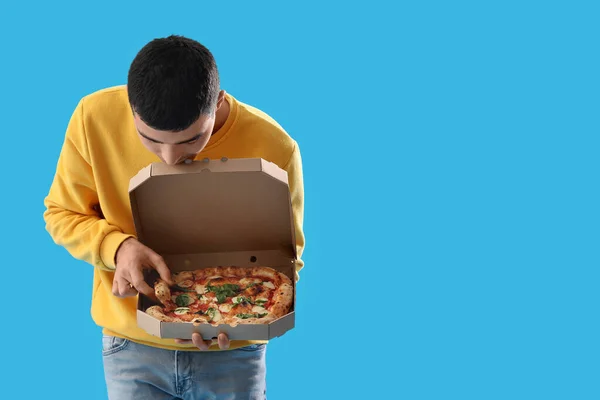 Молодой Человек Коробкой Вкусной Пиццы Голубом Фоне — стоковое фото