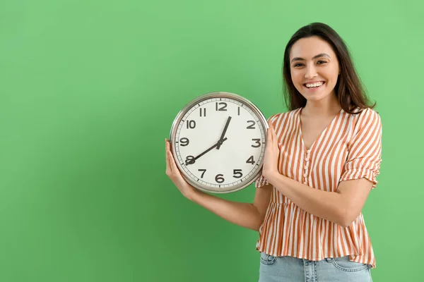 Young Woman Wall Clock Green Background — Stock Photo, Image