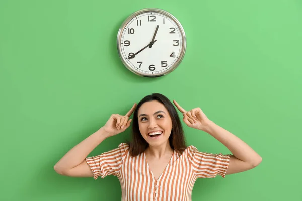 Jeune Femme Pointant Vers Horloge Sur Mur Vert — Photo