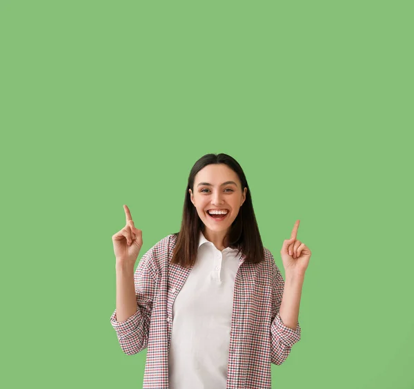 Šťastná Mladá Žena Ukazuje Něco Zeleném Pozadí — Stock fotografie