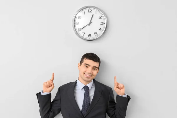 Young Businessman Pointing Clock Light Wall — Stock Photo, Image