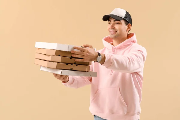 Male Courier Holding Boxes Tasty Pizza Beige Background — Stock Photo, Image