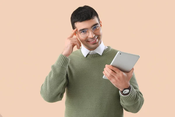 若いです男で眼鏡でタブレットコンピュータでベージュの背景 — ストック写真