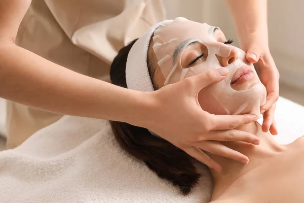 Kosmetolog Tillämpa Sheet Mask Unga Kvinnans Ansikte Salong Närbild — Stockfoto
