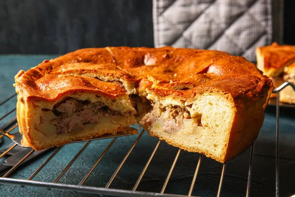 stock image Grid with delicious meat pie on grey grunge table, closeup