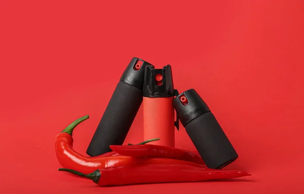 Sprays Con Chiles Sobre Fondo Rojo —  Fotos de Stock