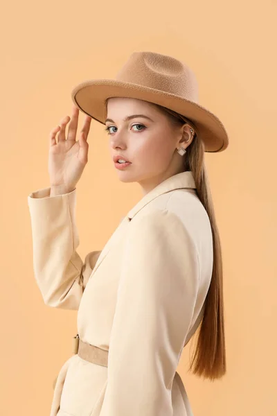 穿着时髦夹克头戴米色背景帽子的时髦年轻女人 — 图库照片