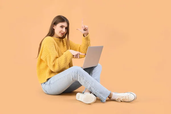 Ung Kvinna Med Bärbar Dator Visar Förlorare Gest Beige Bakgrund — Stockfoto