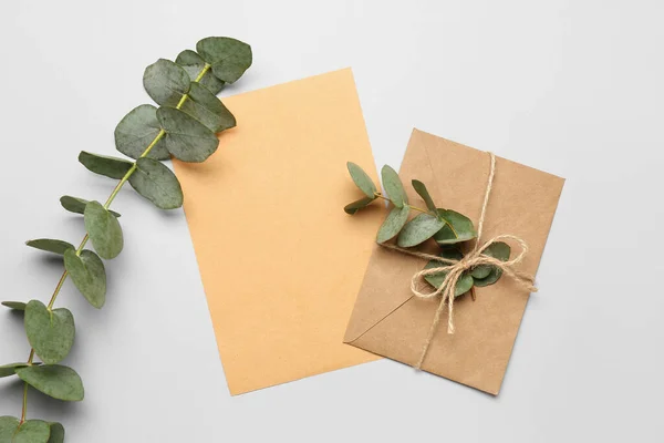 Sammansättning Med Tomt Kort Kuvert Och Eukalyptus Grenar Vit Bakgrund — Stockfoto