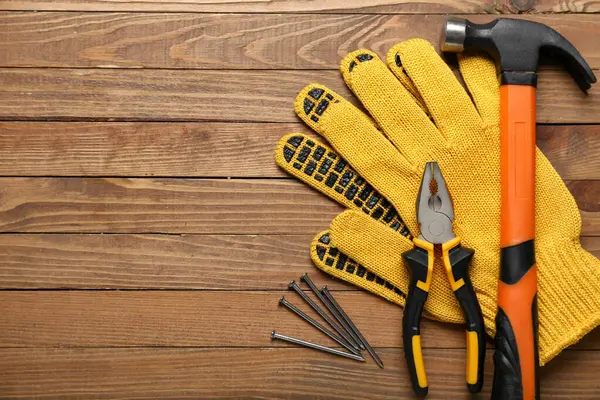 Zangen Handschuhe Und Nägel Auf Holzgrund — Stockfoto