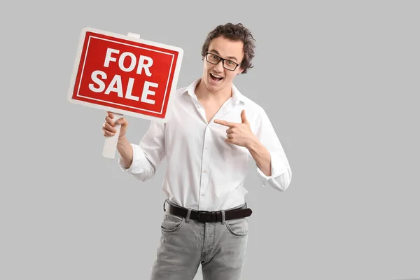 Immobilienmakler Zeigt Auf Sale Schild Auf Grauem Hintergrund — Stockfoto
