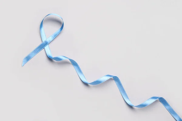 Blue satin ribbon on light background. Prostate cancer concept