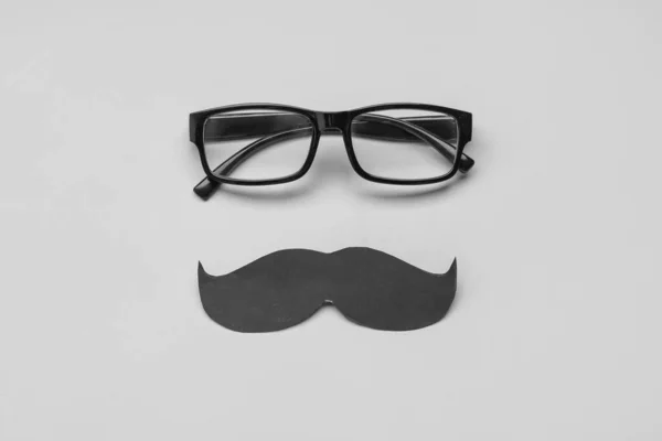 Brille Und Schwarzer Papierschnurrbart Auf Grauem Hintergrund — Stockfoto