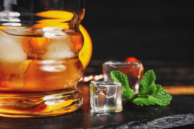 Bir bardak buzlu rom ve nane yaprağı, yakın plan.