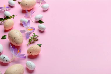 Paskalya yumurtaları, güzel kır çiçekleri ve pembe arka planda bitki yaprakları.