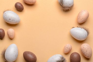 Paskalya yumurtalarından yapılmış, bej arkaplanda tüyler var.