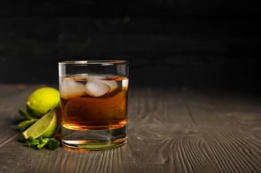 Tahta masada buzlu ve limonlu bir bardak rom.