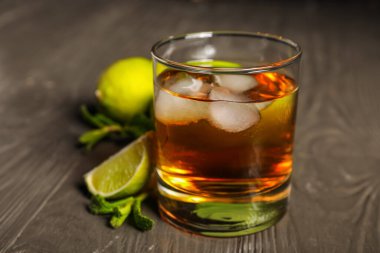 Tahta masada buzlu ve limonlu bir bardak rom.