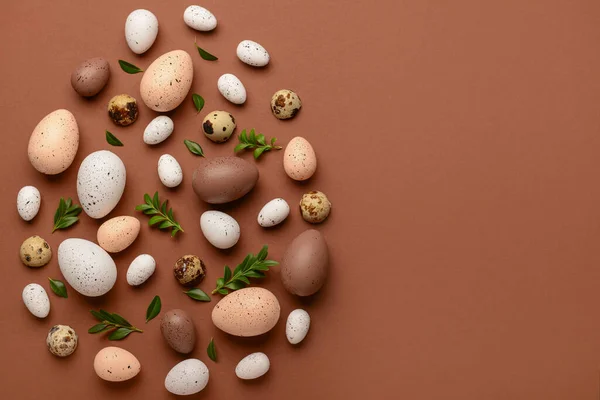 stock image Creative composition with Easter eggs and plant leaves on brown background