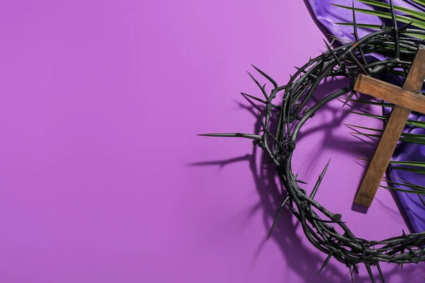 紫色の背景にとげとヤシの葉の冠を持つ木製の十字架 良い金曜日のコンセプト — ストック写真
