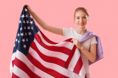 Pembe arka planda ABD bayrağı olan genç bir kadın.