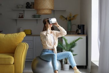 Pretty young woman in VR glasses exercising at home