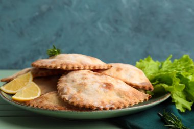 Fırında pişmiş et ve marul, ahşap masa, yakın plan.